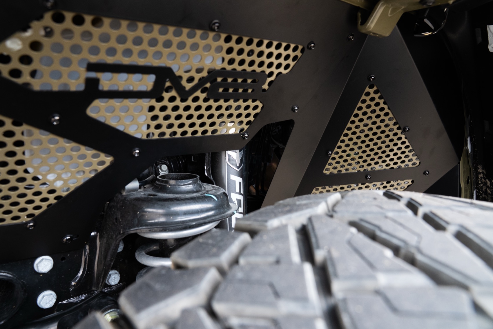 Close view of the DV8 front inner fender and powder-coated mesh insert on the Jeep