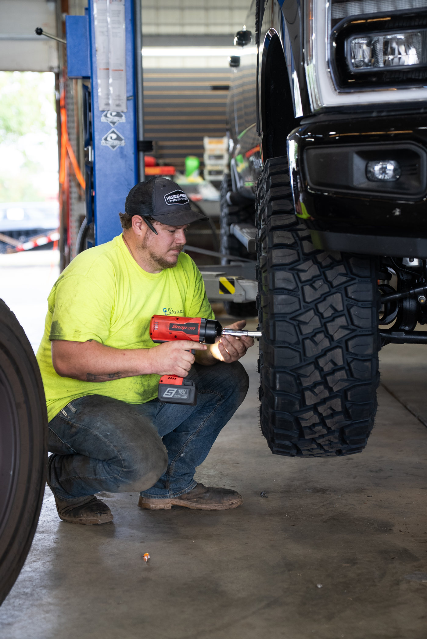 Cody working at a truck wheel inside the APG shop