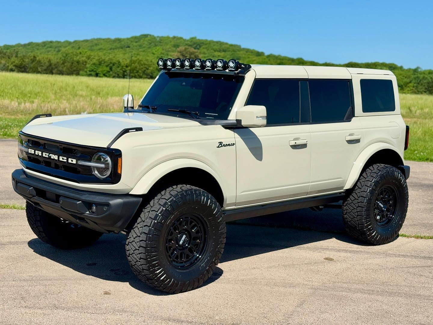 Desert Sand 2025 Ford Bronco with Method wheels, off-road tires, roof light bar and power steps