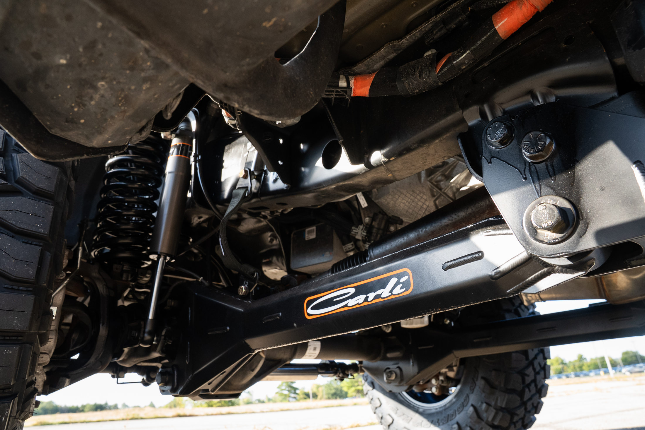 Underside of the completed Ford F-250 showing Carli suspension components and front axle hardware