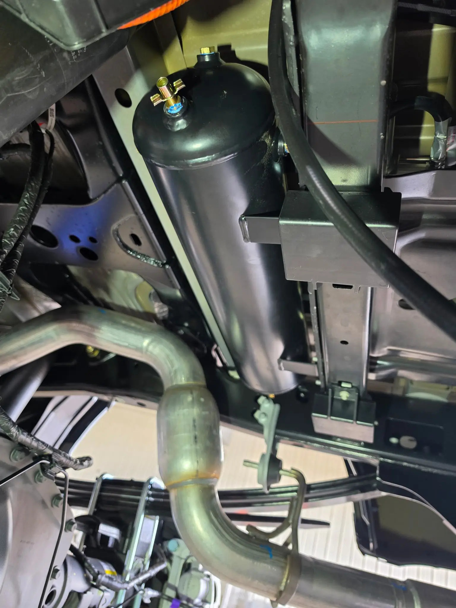 Custom onboard-air tank and compressor mount fabricated beneath a Ford F-350 Tremor