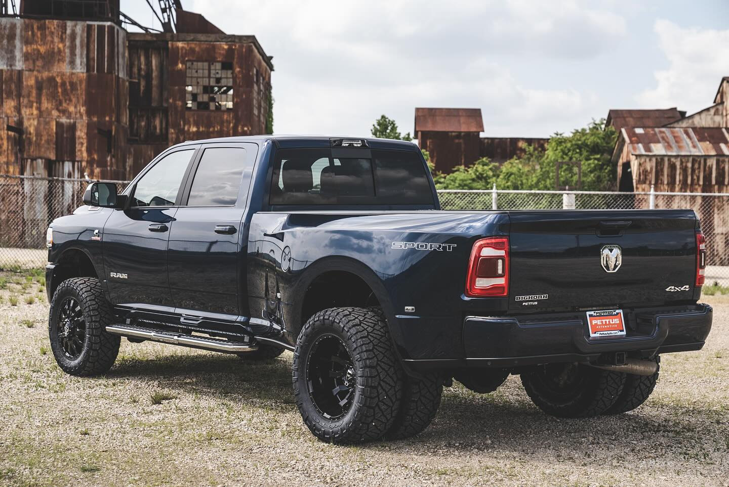 Rear three-quarter view of the same dark blue Ram 3500 Big Horn showing its leveled stance and Nitto tires