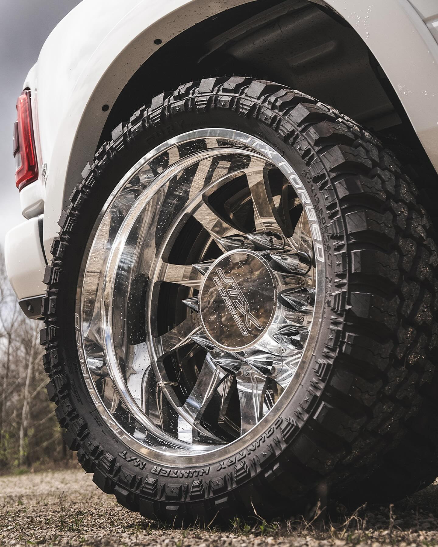 Close-up of a chrome JTX wheel and Fury tire on the same white Ram 3500 Mega Cab Limited