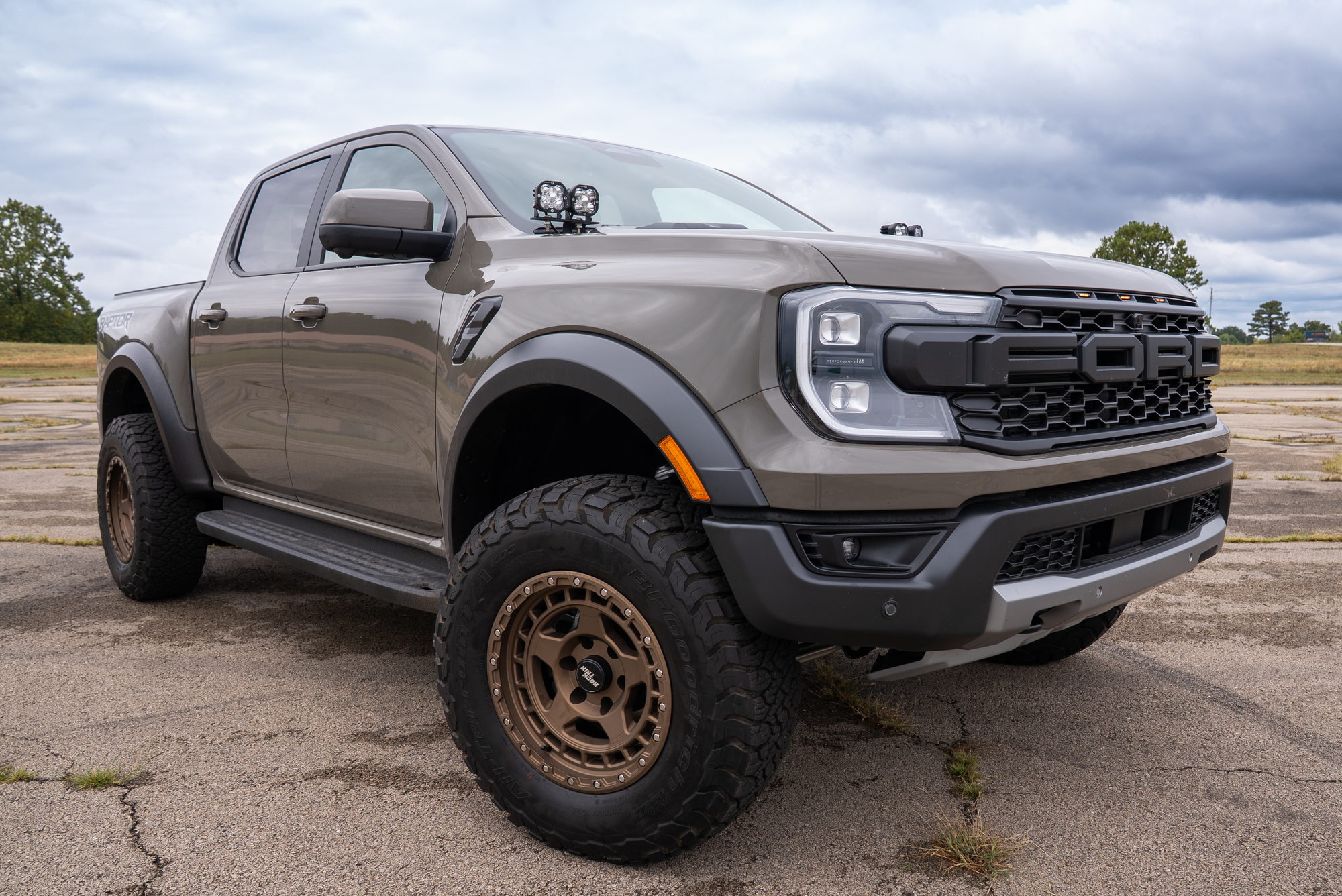 Tan Ranger Raptor with its Rough Country leveled stance and customer-supplied bronze wheels and tires