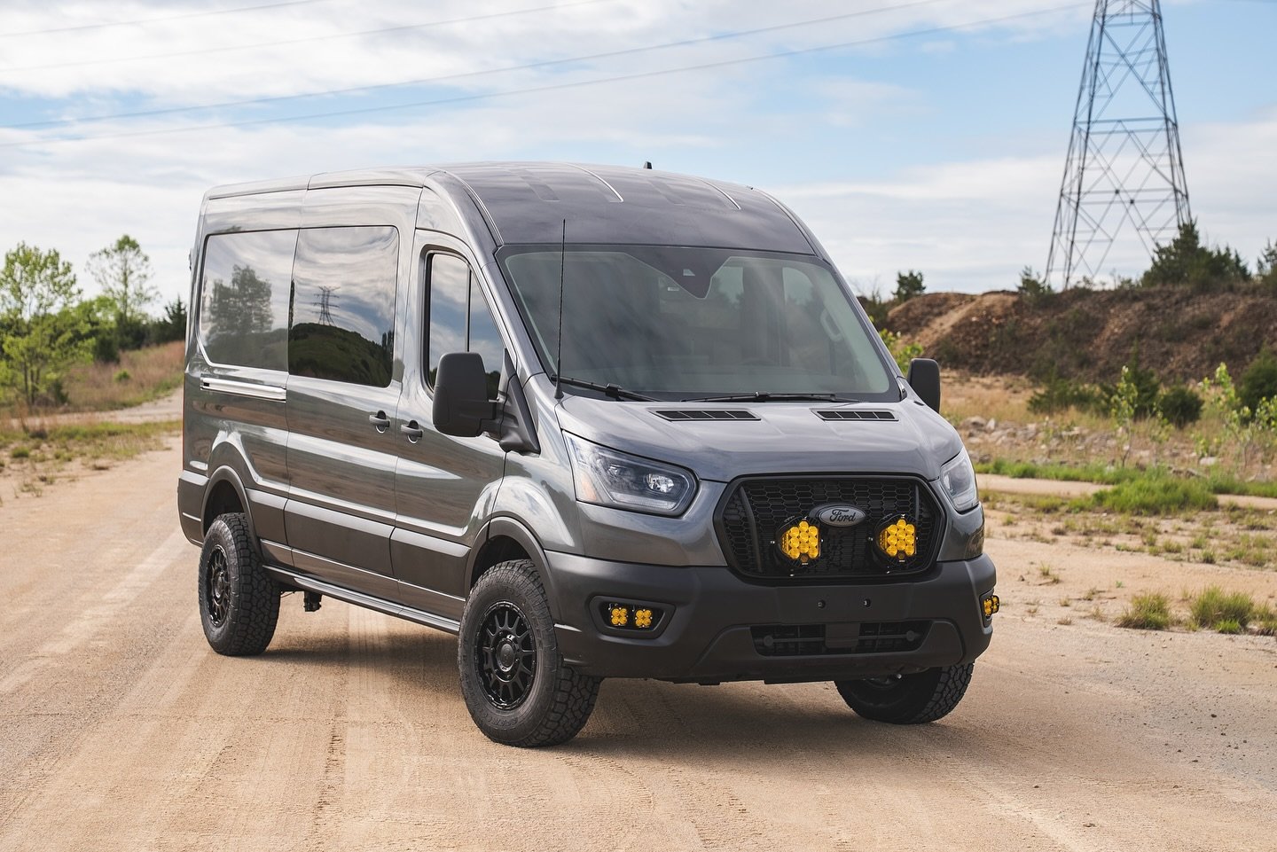 Completed gray 2025 Ford Transit High Roof with amber grille and fog lights, Black Rhino wheels and Toyo tires