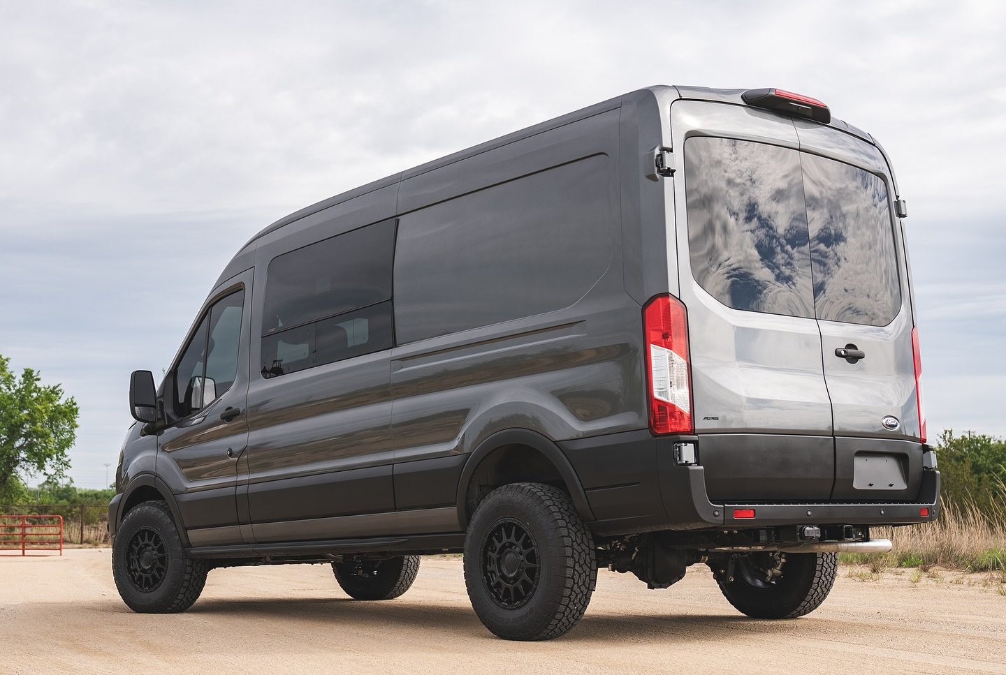 Rear three-quarter view of the completed Ford Transit High Roof showing its lifted stance, side window and wheels