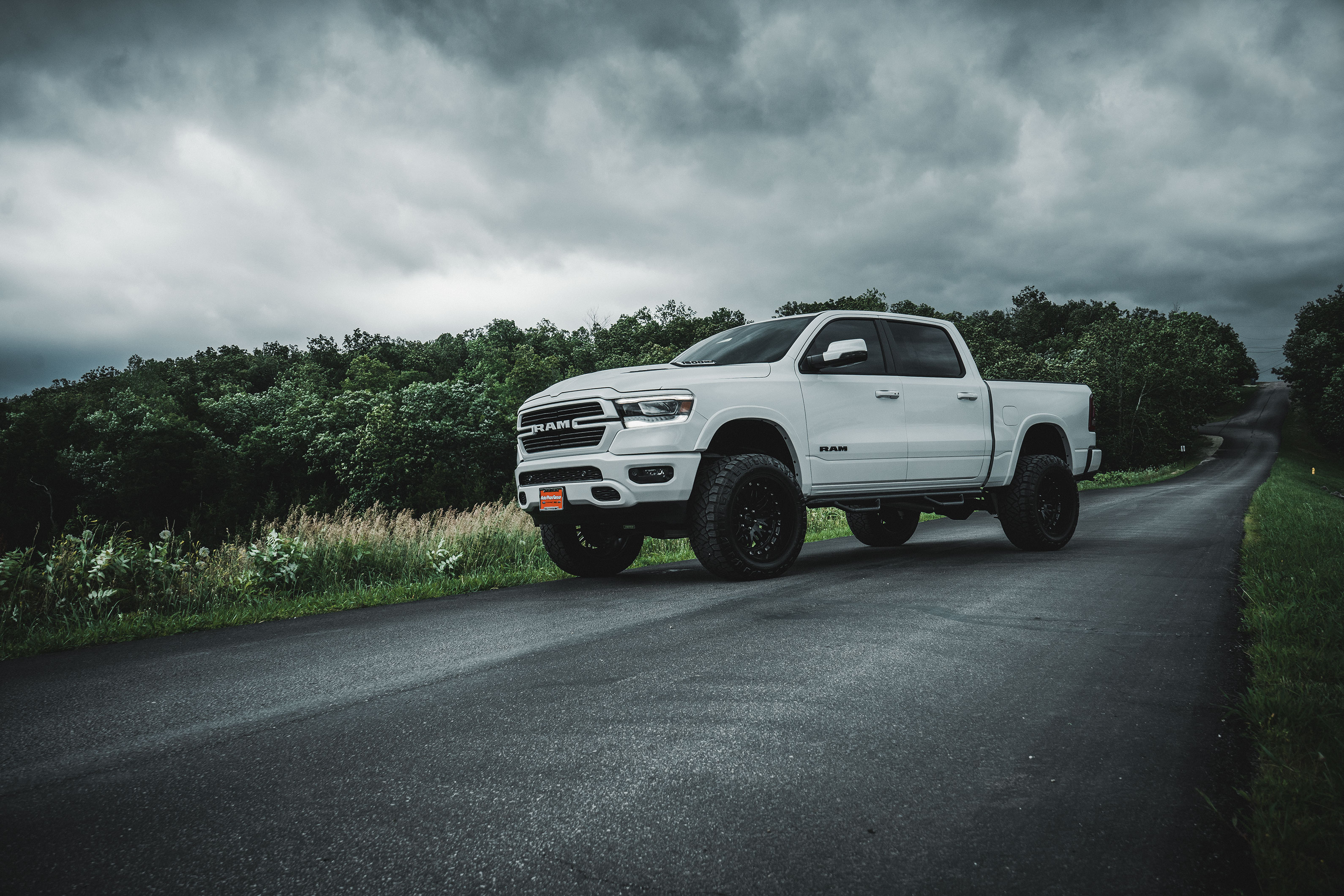 White lifted Ram truck on a winding Missouri road