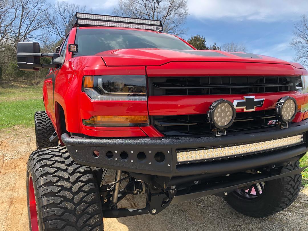 Red lifted Chevrolet truck with custom lighting